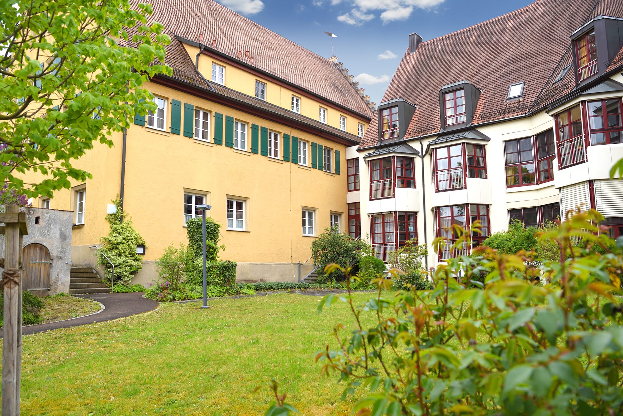 Außenansicht des Alt- und Neubaus mit Garten