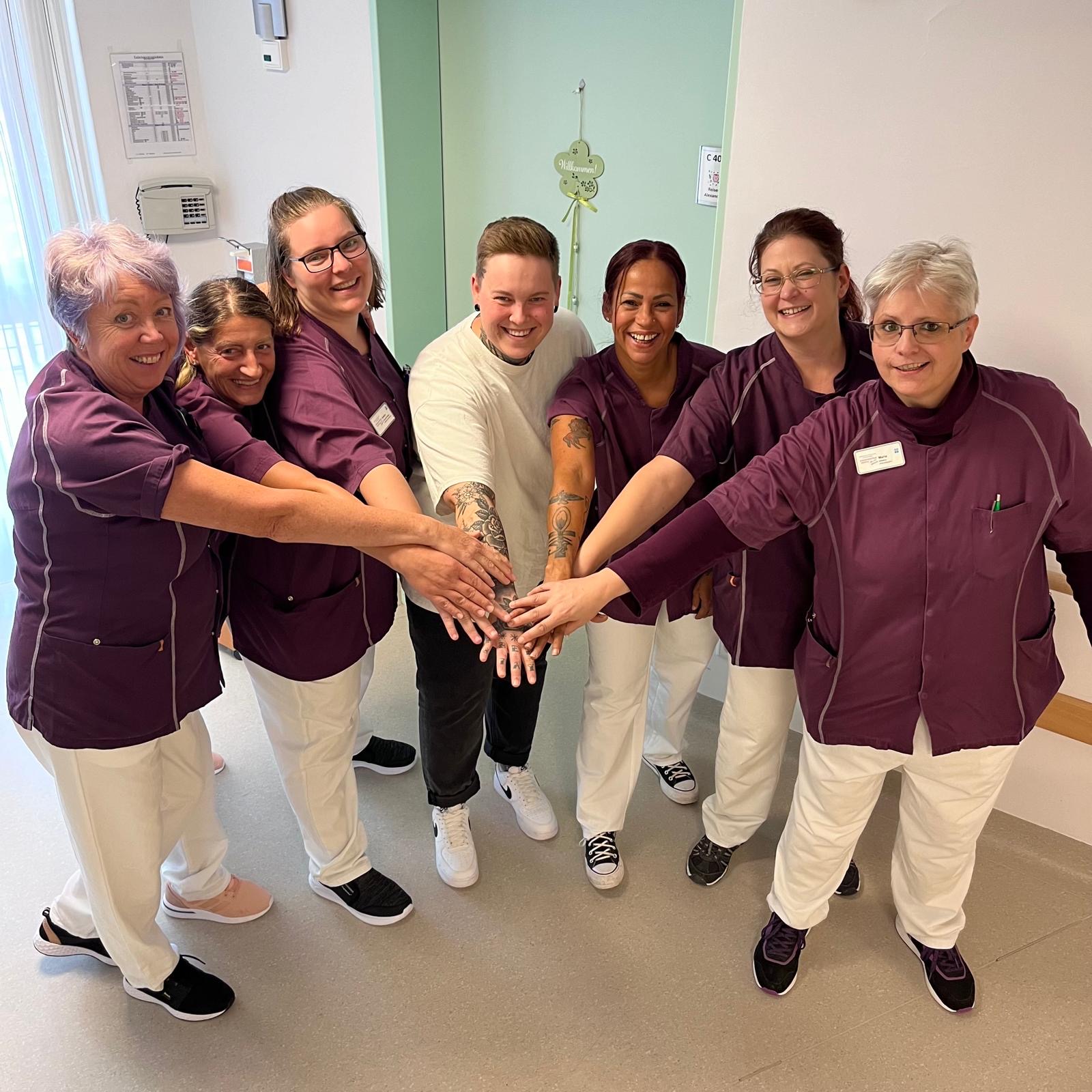 Team des Seniorenzentrum Hospital halten Hände zusammen